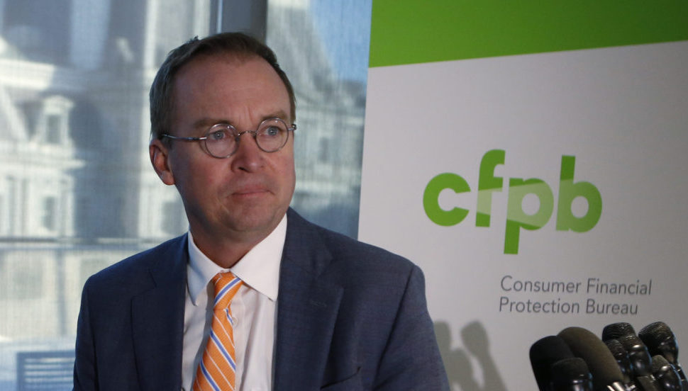 Mick Mulvaney in front of CFPB sign